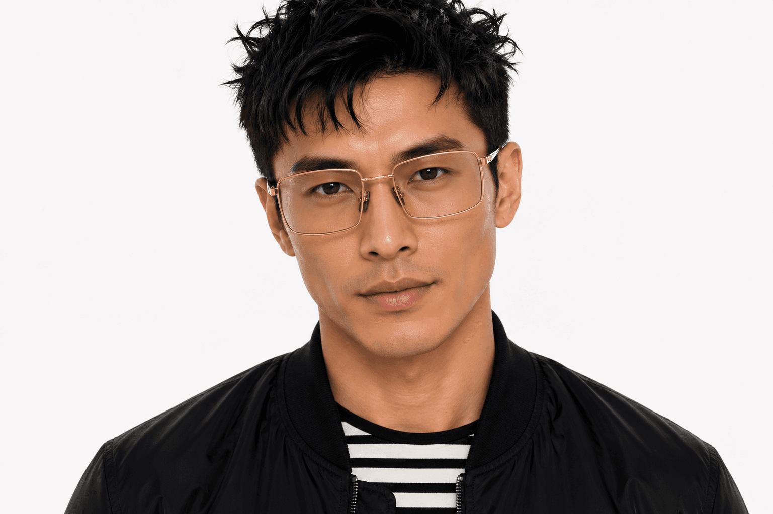 A man wearing the gold rimless Eye Ware frames against a white studio backdrop